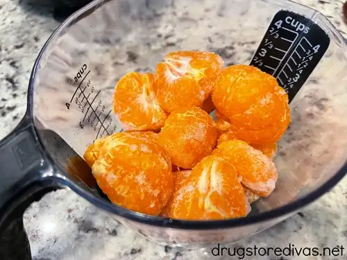 Frozen mandarin orange pieces in a measuring cup.