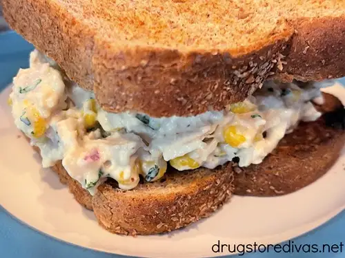 A Mexican street corn chicken salad sandwich on a blue and white plate.