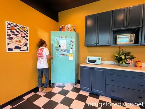 A man opening a blue fridge in a kitchen in The Rift in the Cargo District in Wilmington, NC.