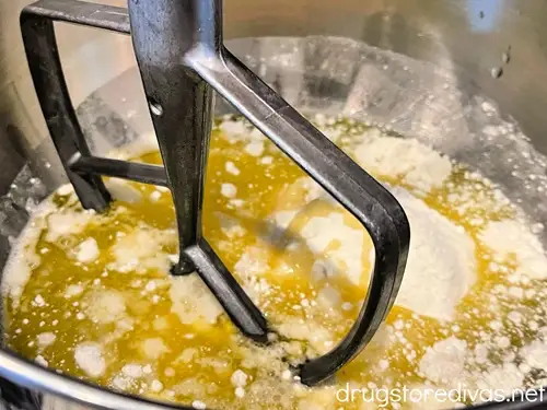 Cake mix ingredients in a stand mixer bowl with a paddle attachment.
