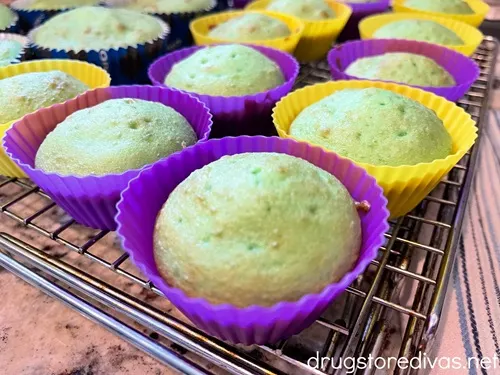 Green cupcakes in purple or yellow cupcake liners are a wire rack.