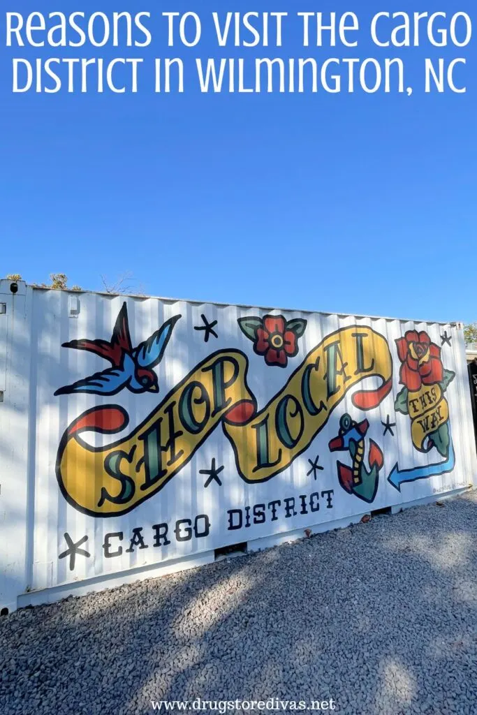 A mural advertising the Cargo District on the side of a shipping container with the words "Reasons To Visit The Cargo District In Wilmington, NC" digitally written on top.