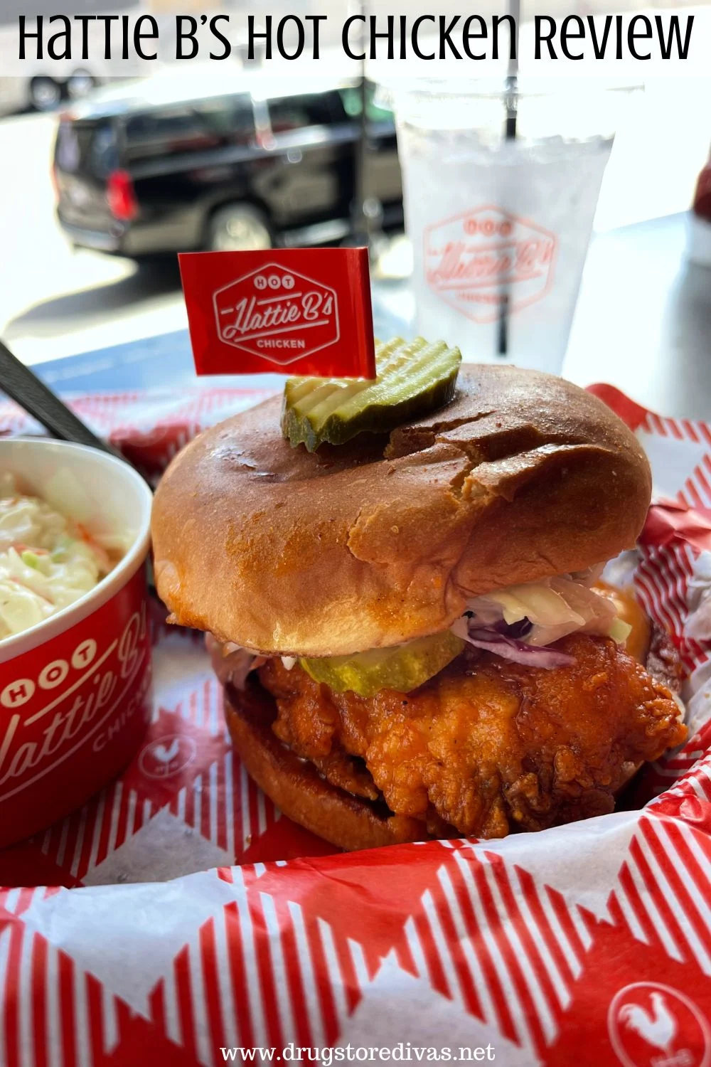 A chicken sandwich and coleslaw in a red bowl in a basket with red and white paper below it with a cup of water behind it and the words 