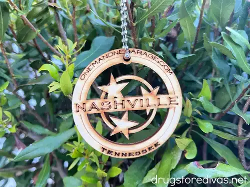 A wooden, circular ornament that says Nashville on a tree.