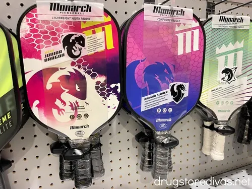 Pickleball paddles on a shelf in a store.