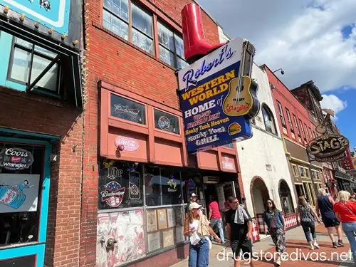 The outside of a bar called Robert's Western World, which has a sign with a guitar and a boot on top, on Broadway in Nashville.