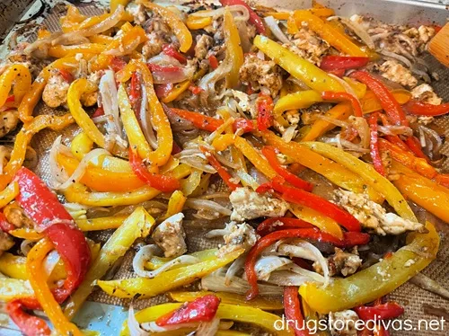 Cooked sheet pan chicken fajitas ingredients on a sheet pan.