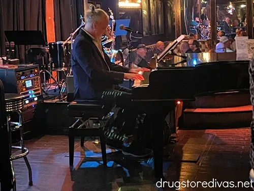 A man, dressed in black, playing the piano inside Skulls Rainbow Room in Nashville.