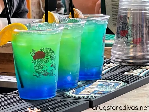 Three green and blue drinks, with lemon wedges in them, on the bar at Teddy's Tavern in Nashville.