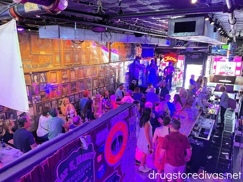 The inside of Tootsie's Orchid Lounge in Nashville, with a very small stage with three musicians on it in the back left, a bar and patrons filling the rest of the photo.