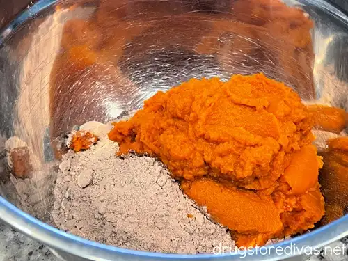 Brownie mix and pumpkin puree in a silver bowl.