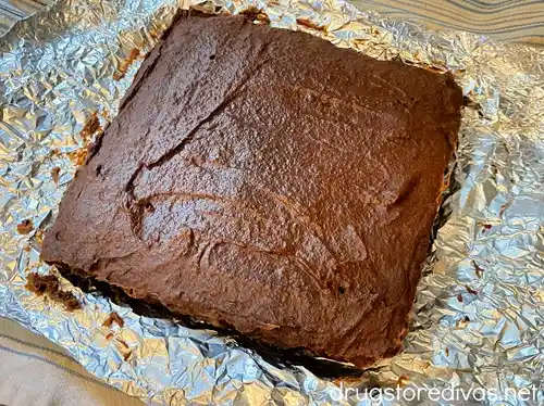 Uncut baked brownies on top of a piece of foil.
