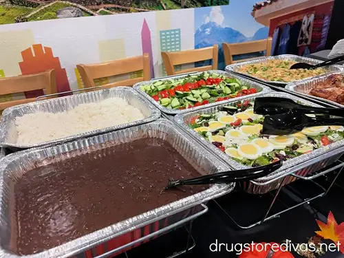Catering trays with black beans, rice, and salads in them at Alpaca Chicken.