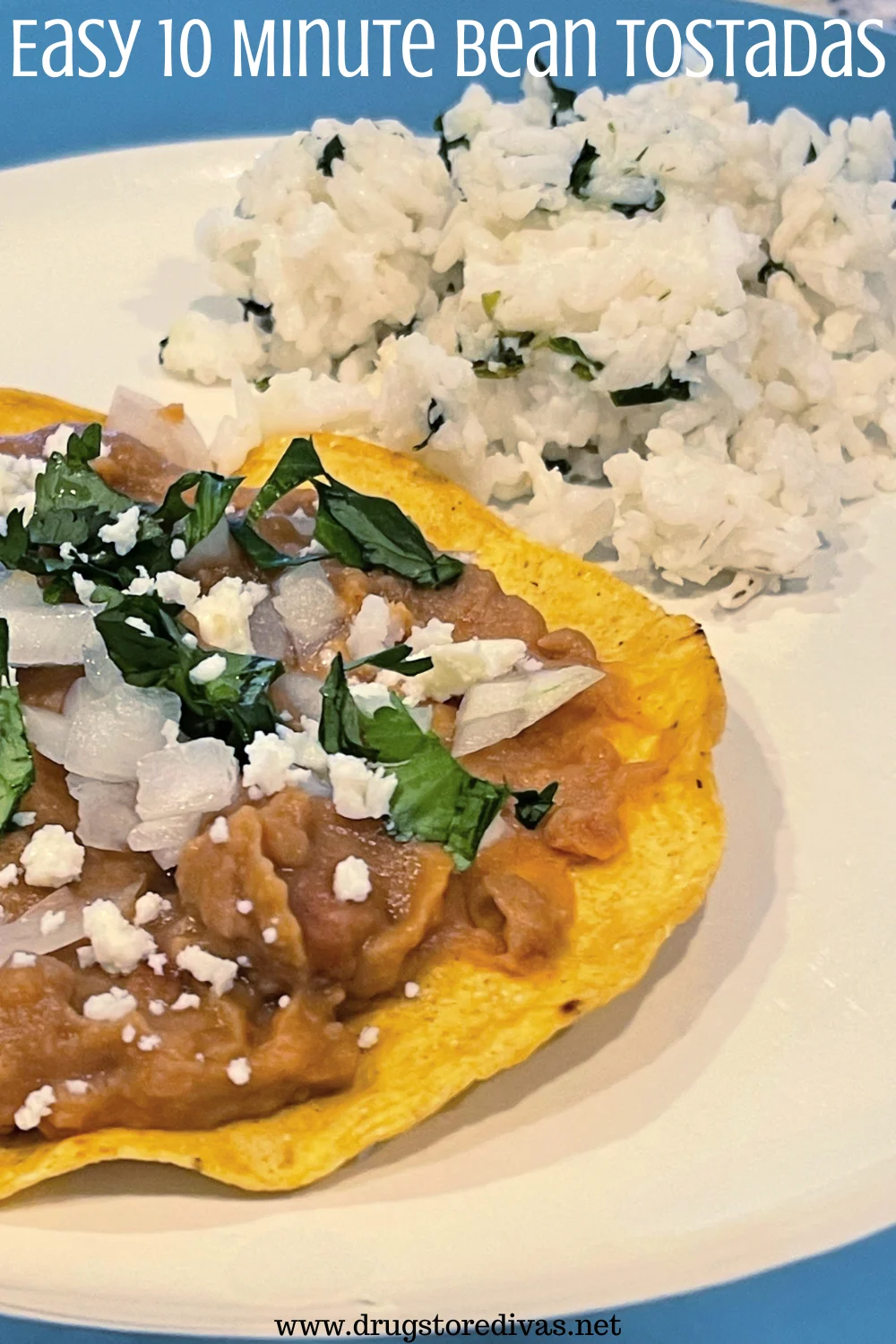 A bean tostada with cilantro, onion, and cheese on top next to cilantro rice on a plate with the words 