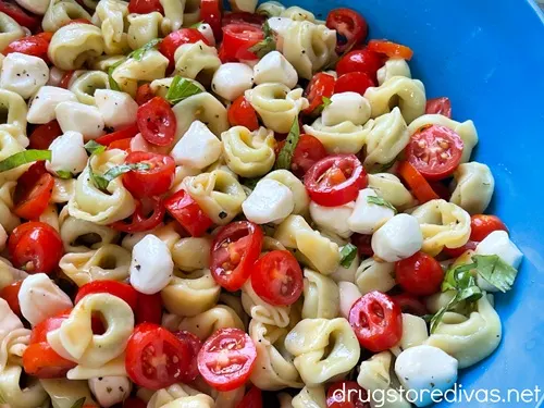 Caprese tortellini salad in a blue bowl.