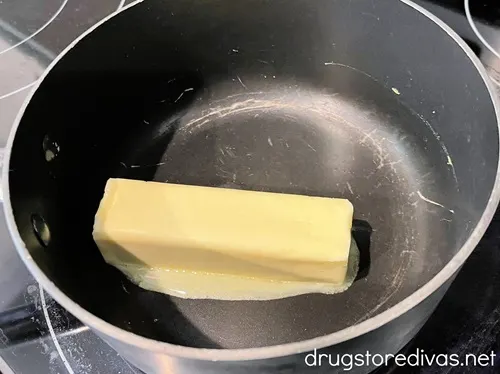 A stick of butter that's starting to melt in a stock pot.