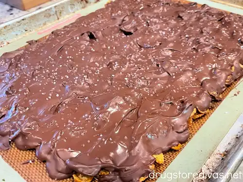 Sea salt topped chocolate-covered corn flakes on a tray.