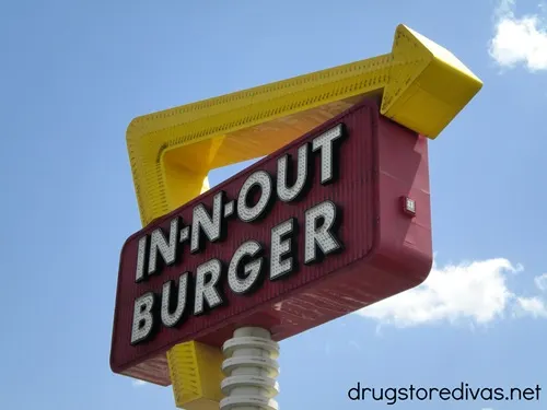 A sign outside an In-N-Out Burger that is advertising the restaurant.