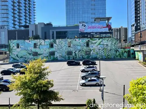 A parking lot with a large mural on the wall behind it in The Gulch in Nashville.