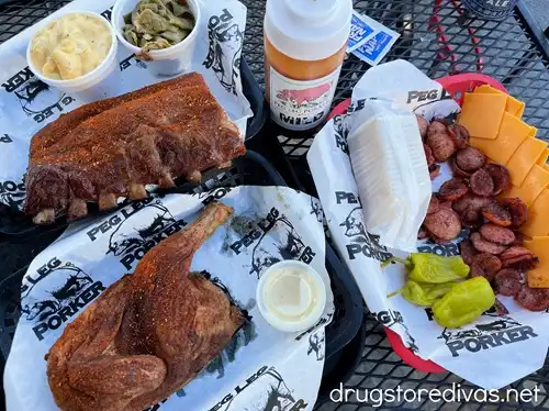 Dry rubbed meats, cheese, and sides from Peg Leg Porker on a table in the Gulch in Nashville.