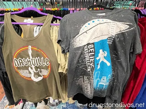 Two Nashville-themed shirts for sale in a store.