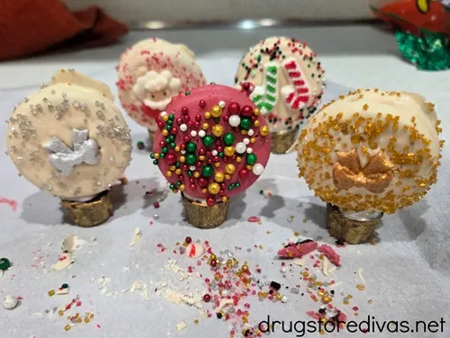 Five decorated Oreo cookies balancing on gold Rolo candies.