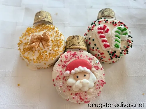 Three Oreo cookies decorated to look like Christmas ornaments.