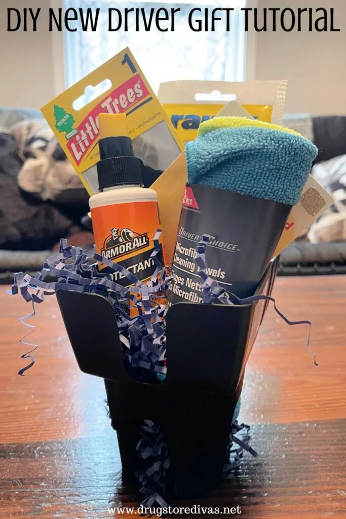A car cup holder filled with car items on a table with the words "DIY New Drive Gift Tutorial" digitally written on top.