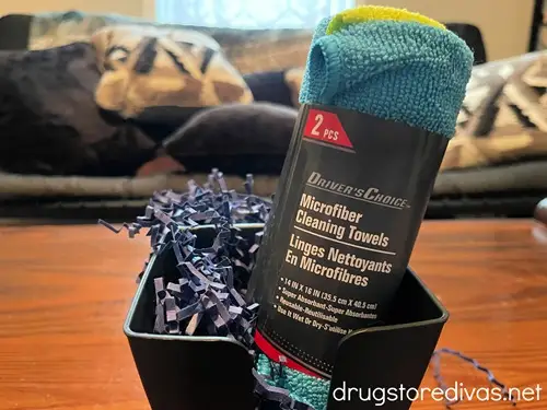 A microfiber towel and blue paper shred in a car cup organizer.