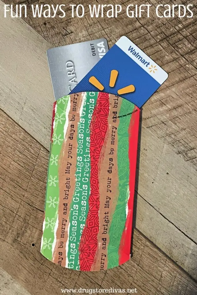A gift card holder with two gift cards coming out of the top with the words "Fun Ways To Wrap Gift Cards" digitally written on top.