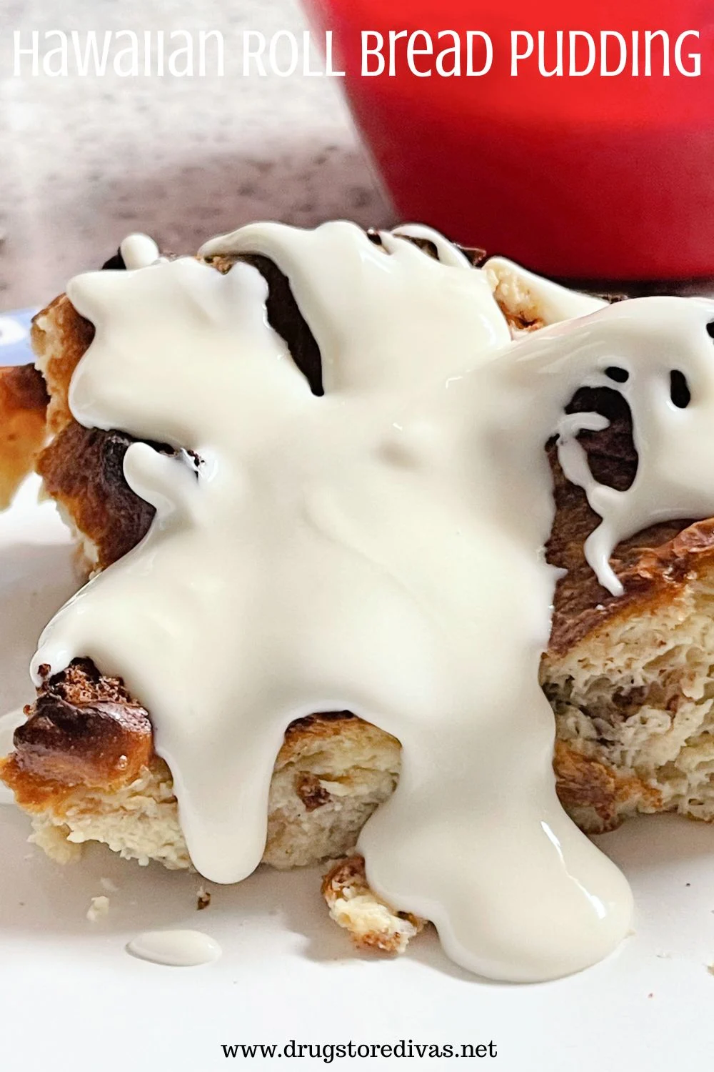 Bread pudding with white sauce on top on a white plate with a red bowl behind it and the words