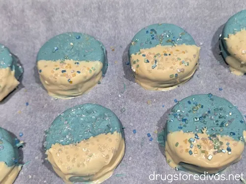 Blue and white chocolate dipped Oreo cookies with sugar sprinkles on them.