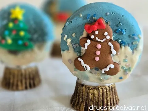 Three Oreo snow globe cookies with gold bases.