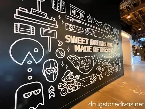 A black wall with white video game images on it that says "Sweet Dreams Are Made Of These" on it.