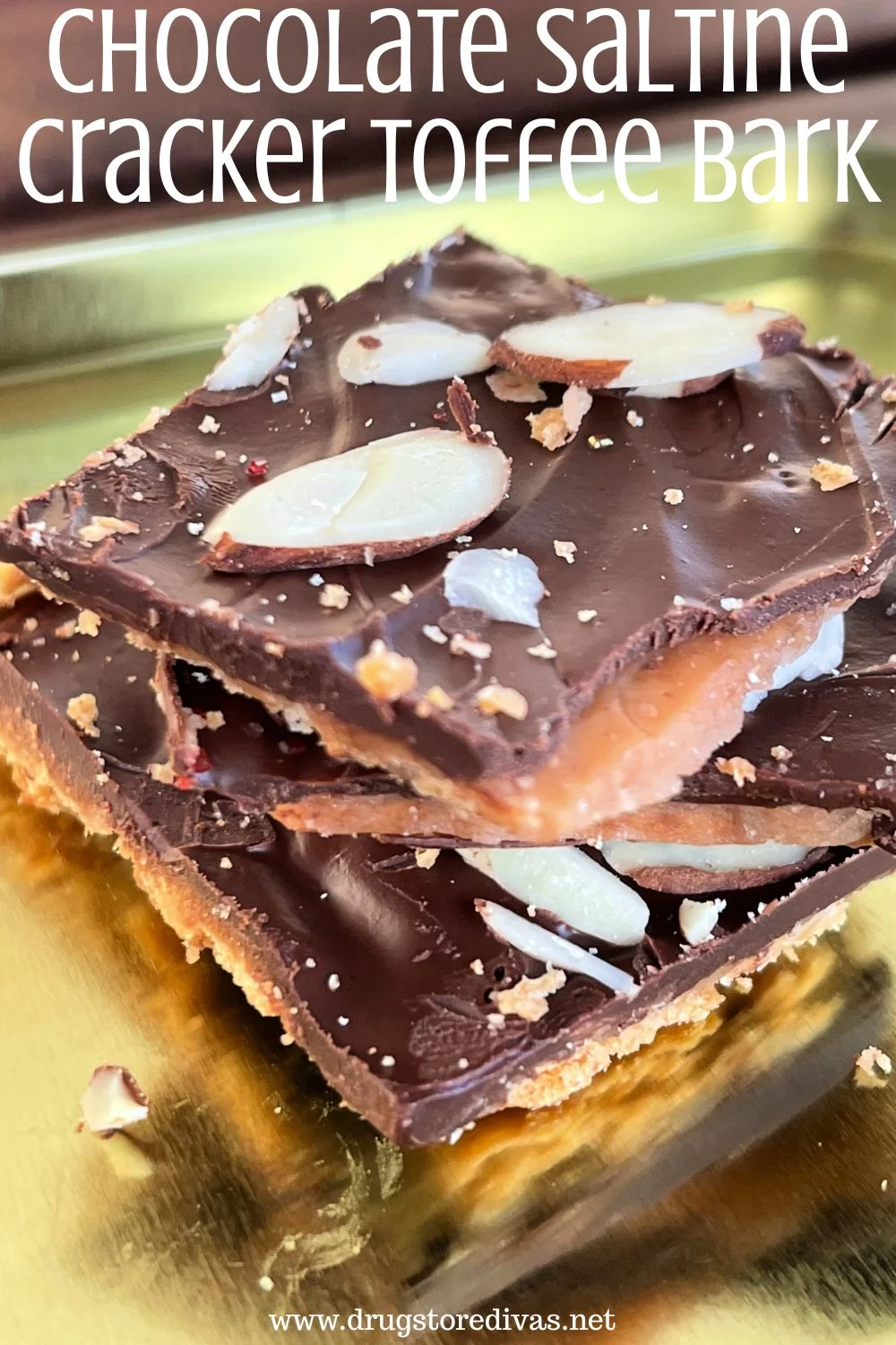 Pieces of toffee bark with almonds on top stacked on a gold tray with the words 