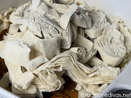 Strips of phyllo dough in a white pan.