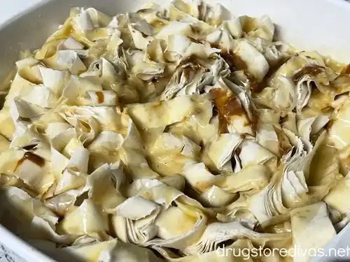 Phyllo dough strips, covered with a yellow custard, in a white pan.