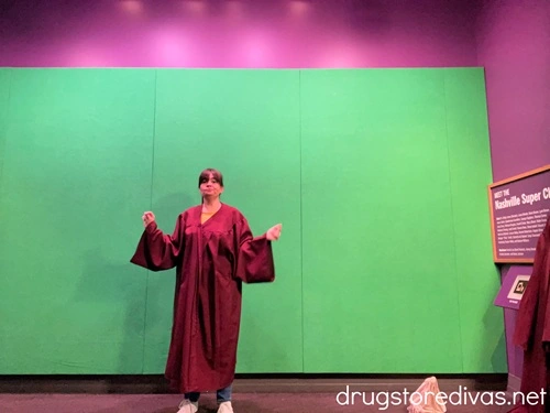 A woman in a church gown in front of a green screen at the National Museum Of African American Music in Nashville.