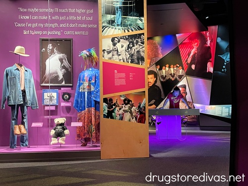 A display, with clothing and a teddy bear behind glass, at the National Museum Of African American Music in Nashville.
