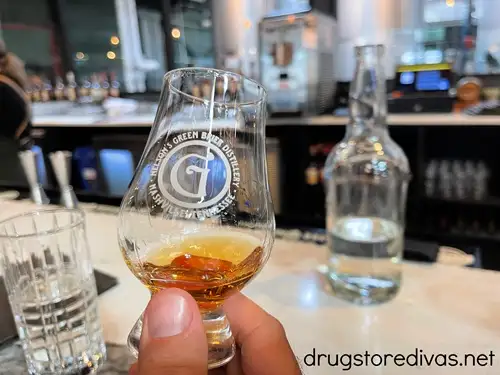 A hand holding a taster glass of alcohol in Nelson's Green Brier Distillery in Marathon Village in Nashville.