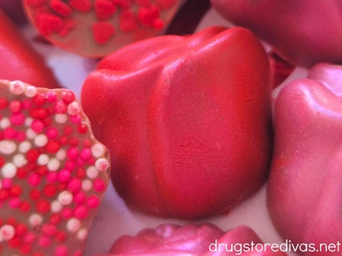 Pink and red glittered chocolate roses next to chocolate roses with sprinkles on them.