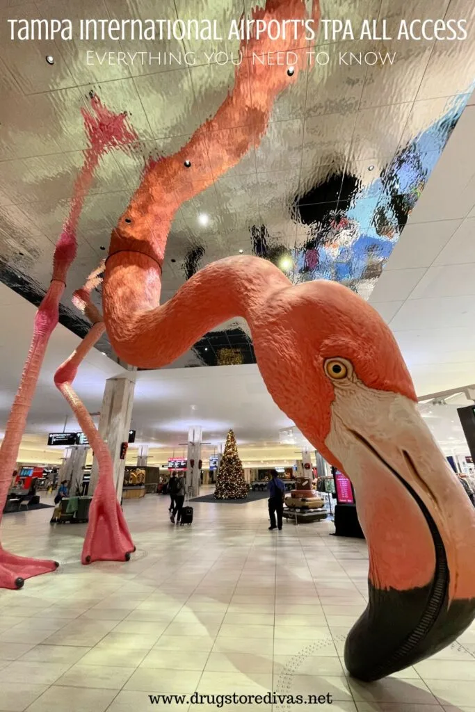 TPA All Access allows non-flyers access to Tampa Airport's stores, restaurants, and amenities. Find out all about it on www.drugstoredivas.net. #ExploreTPA The floor-to-ceiling flamingo statue in the Tampa Airport with the words "Tampa International Airport's TPA All Access Everything you need to know" digitally written above it.