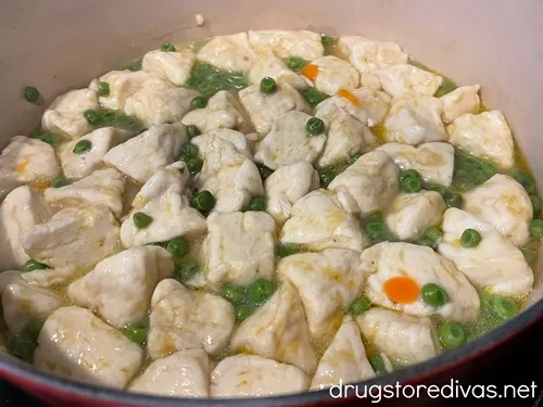 Chicken and dumplings, with peas and carrots, in a Dutch oven.