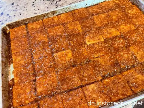 Saltine crackers with toffee on them on a baking tray.