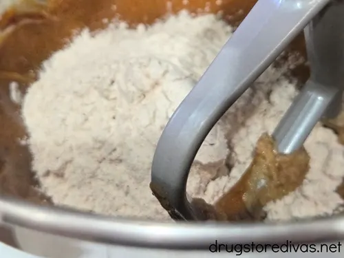 Cookie mix being stirred in a stand mixer bowl.