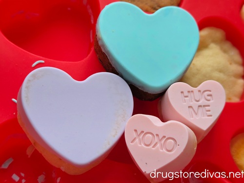 Conversation Heart Cookies resting on a red mold.