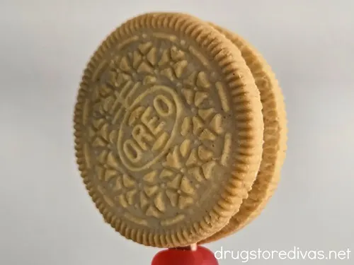A Golden Oreo cookie with a red candy Dot at the base.