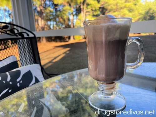 A hot chocolate affogato in an Irish coffee glass on a table.