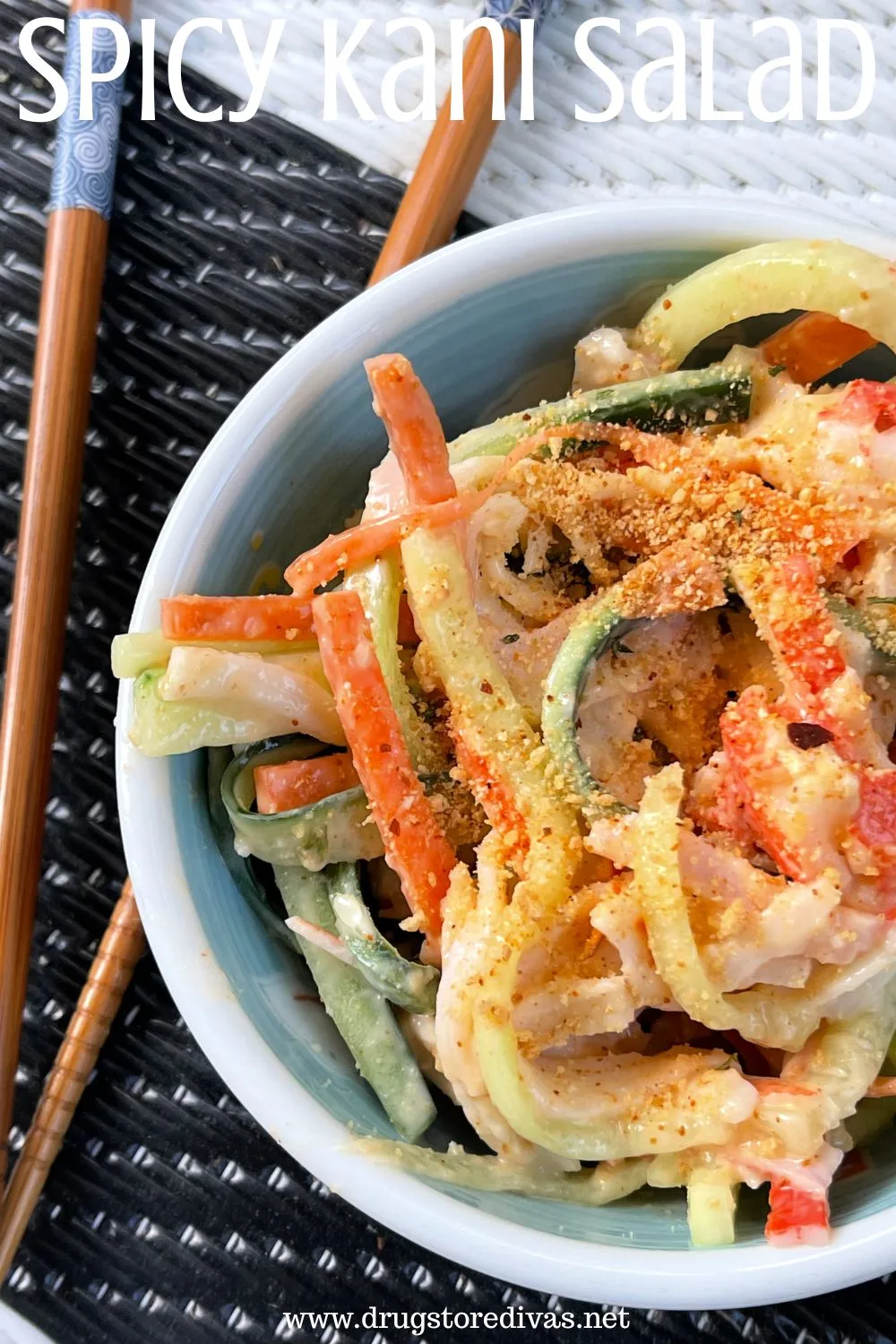Chopsticks on the side of a bowl that has julienned carrots and cucumber with crab in it and the words 