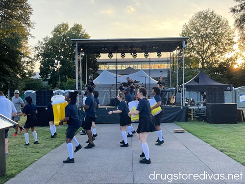A stage with dancers in front, some holding inflatable beer glasses, at Nashville Oktoberfest.
